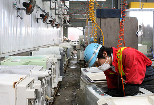 冷蔵庫を解体する男性